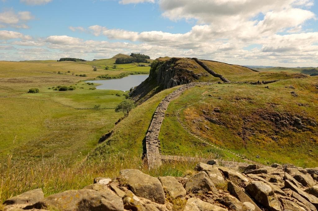 Walking along Hadrian's Wall ridge with expansive panoramic hillside views