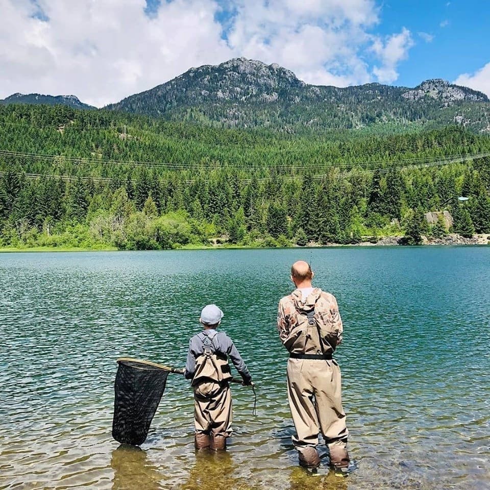 Father and child fishing at alpine lake, family fly-fishing outing