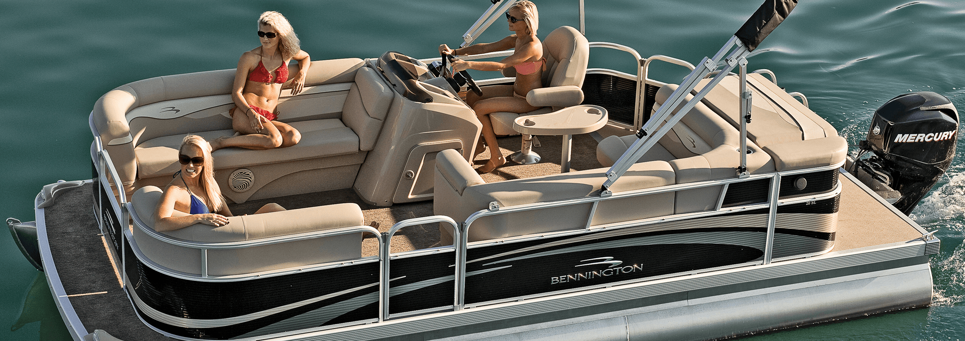 Friends relaxing on pontoon boat cruising calm lake at sunset