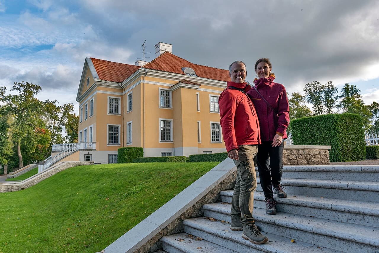 Couple walking steps at historic Estonian manor house grounds