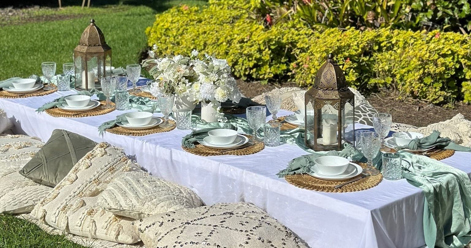 Bohemian low picnic setup with cushions and lanterns on lawn