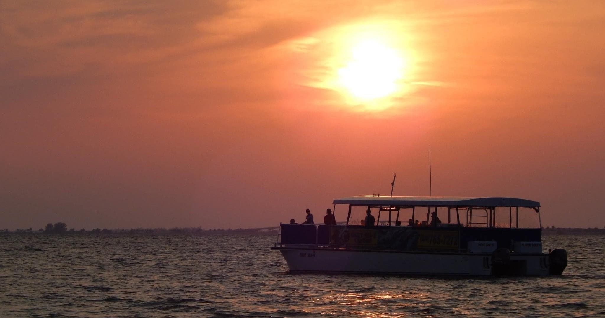 Sunset tour boat cruising Gulf horizon near Fort Myers Beach
