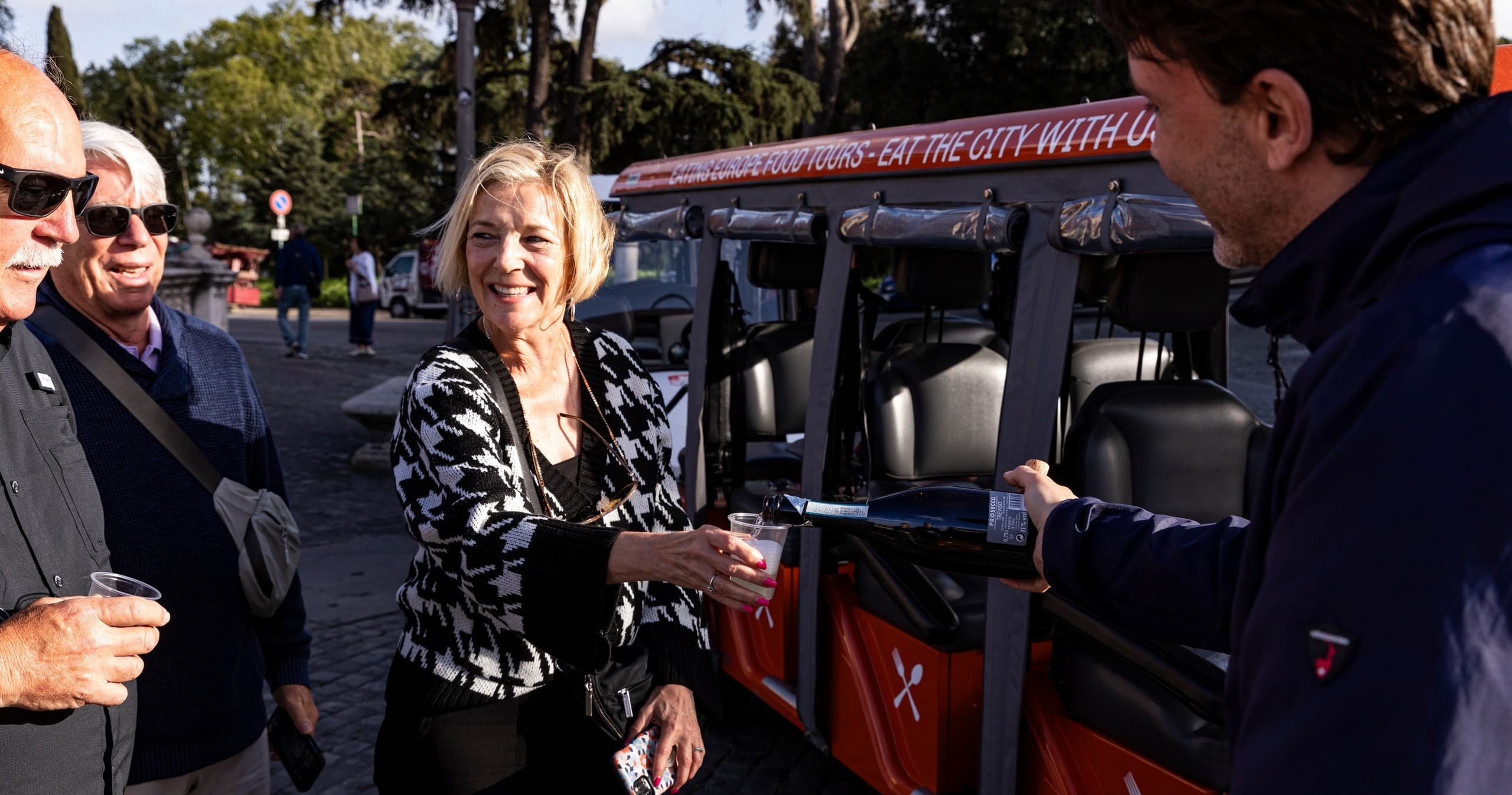 Guests boarding small open-air tour vehicle in Rome streets