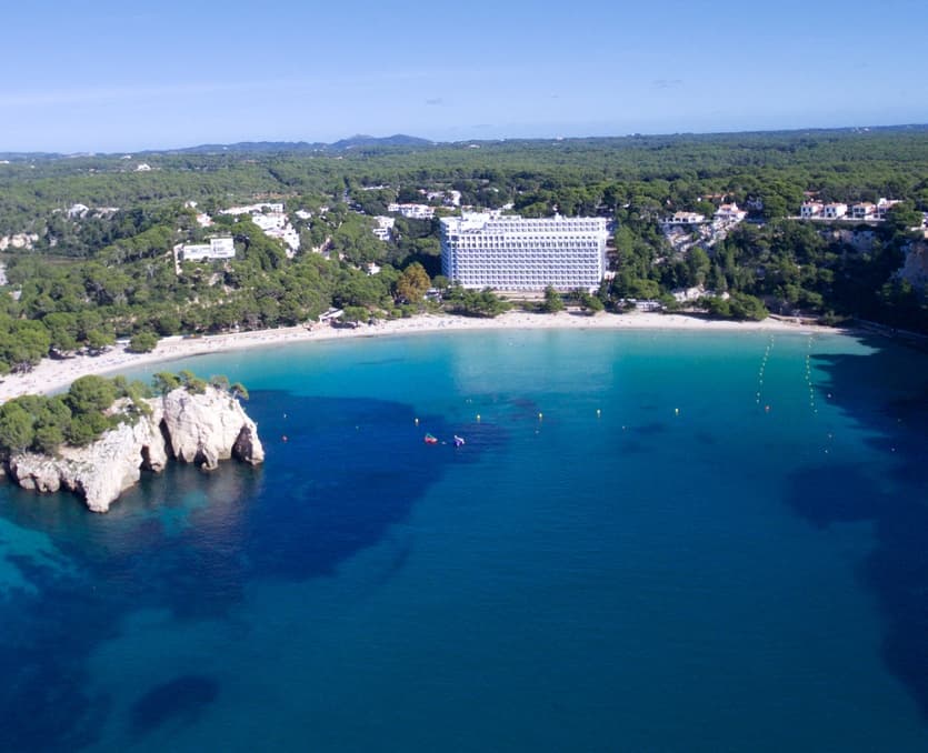 Aerial view of turquoise bay and sandy beach near resort