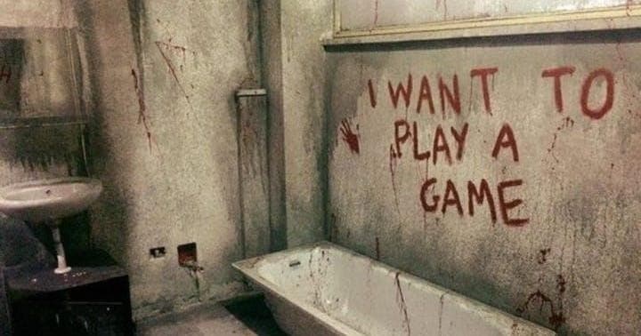 Derelict bathroom with 'I want to play a game' graffiti in ruin