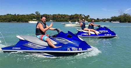 Group riding blue jet skis on turquoise coastal water