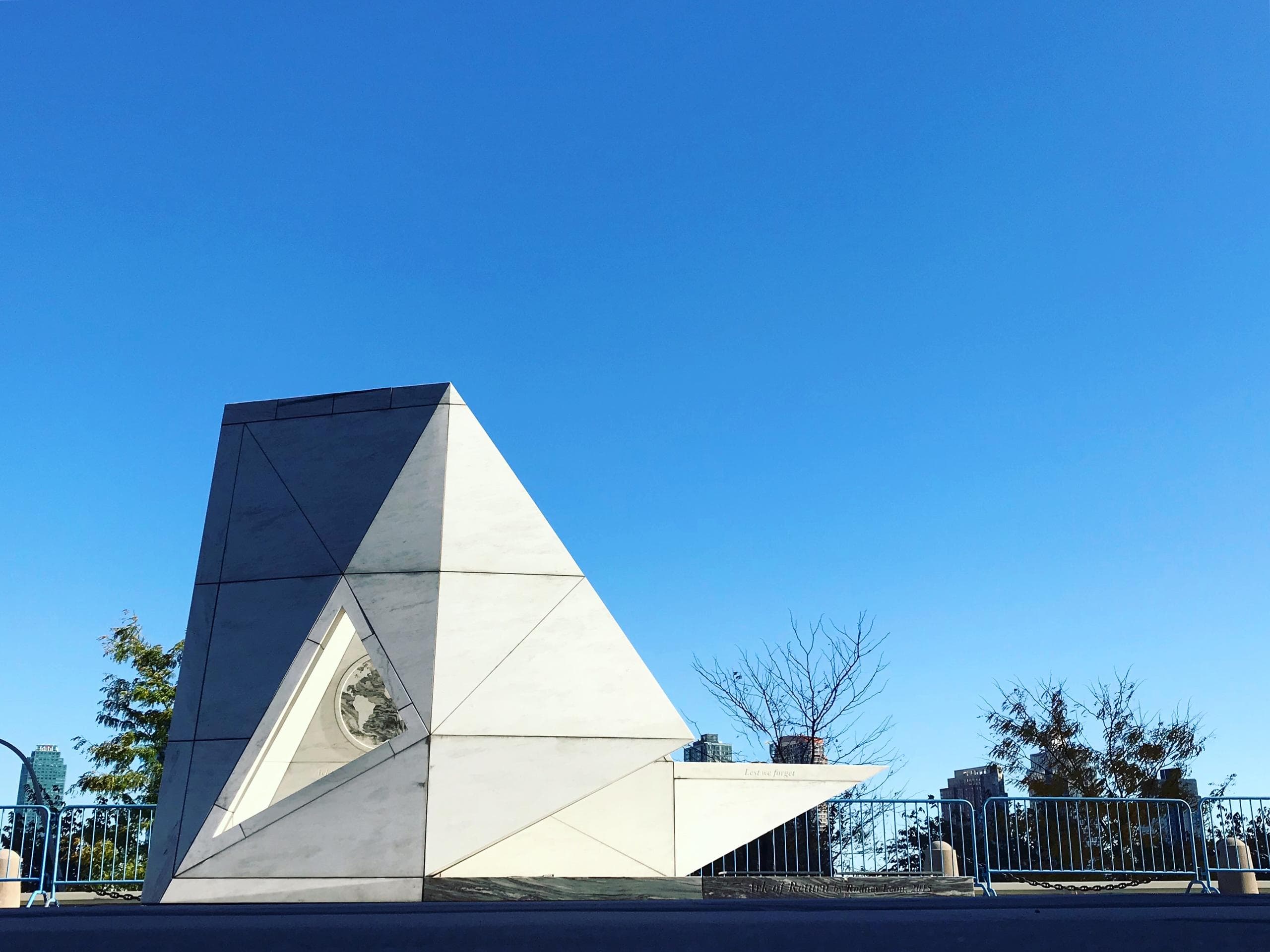 Geometric memorial building under blue sky at outdoor plaza