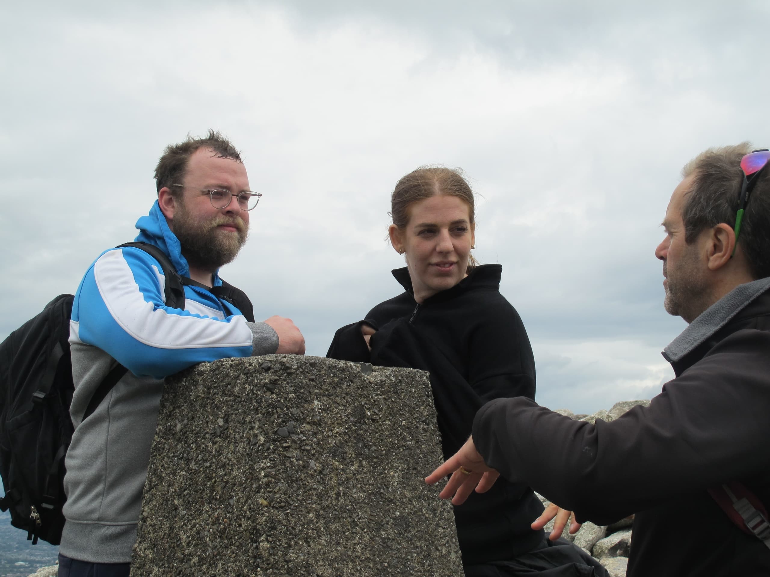 Group at summit trig point enjoying panoramic mountain view