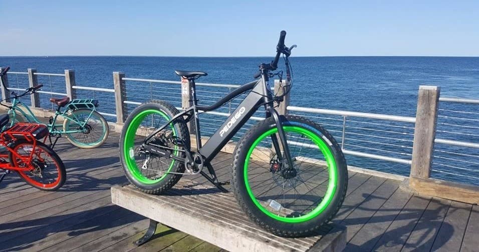 Fatbike parked on wooden pier overlooking open ocean