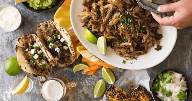 Tabletop taco spread with lime and garnishes, vibrant food shot
