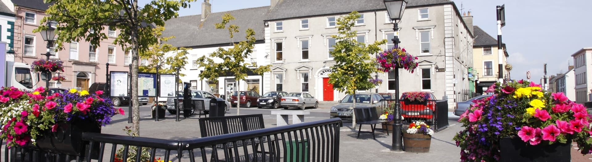 Town square with outdoor seating and flower displays in Mountmellick