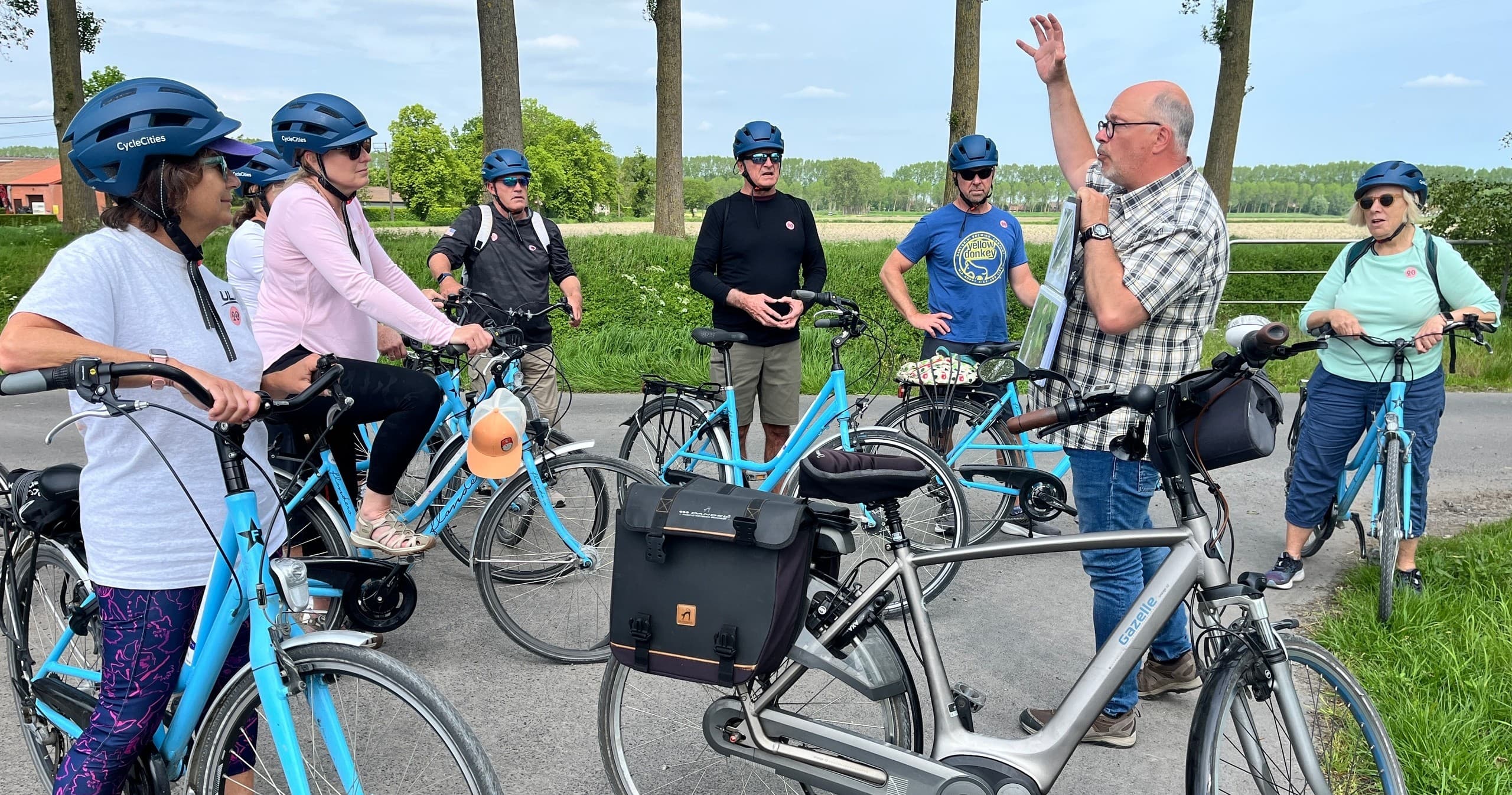 Guided group bicycle tour on country road with local guide briefing
