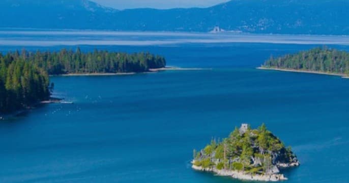 Scenic island in alpine lake with evergreen shoreline, ideal for sightseeing