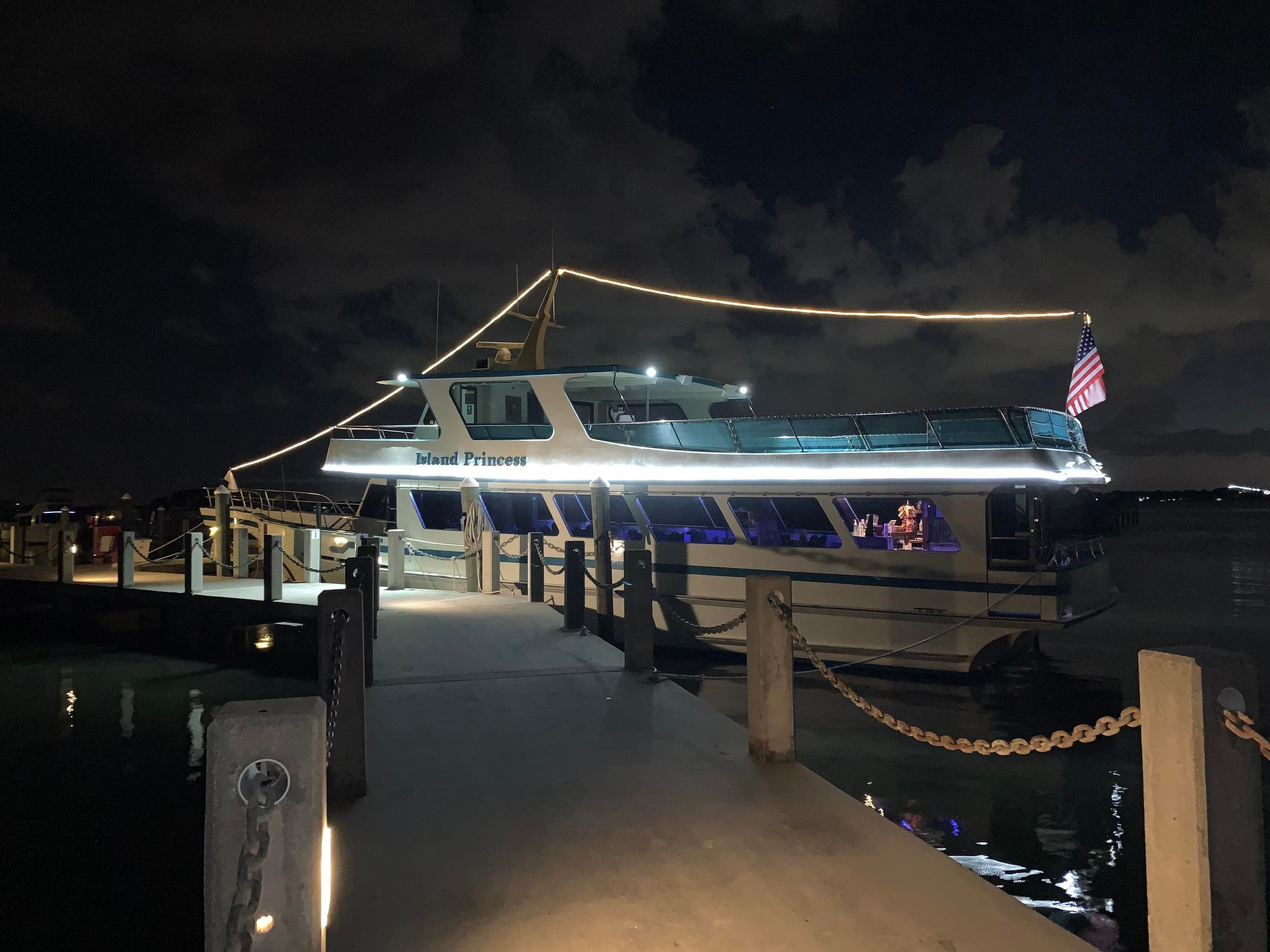 Nighttime harbor cruise yacht lit at dock for evening sightseeing