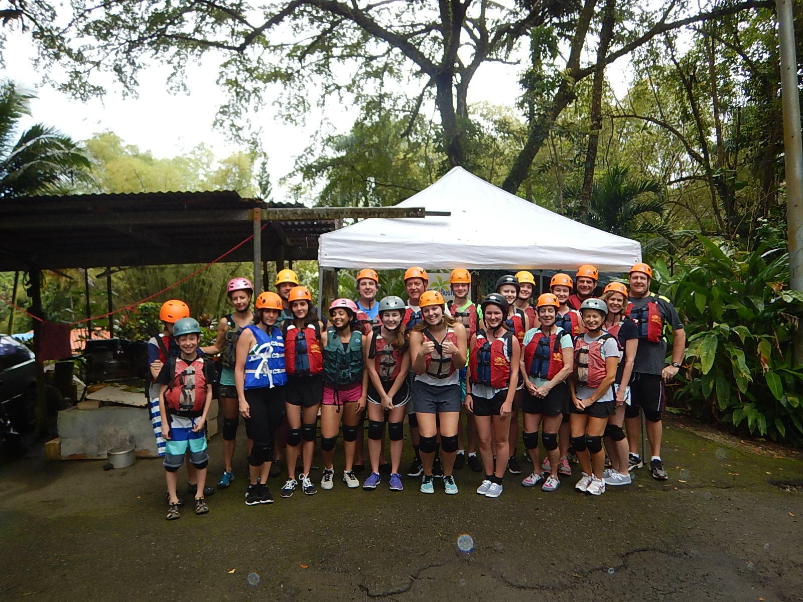 Group of zipline adventurers gathered in lush tropical forest