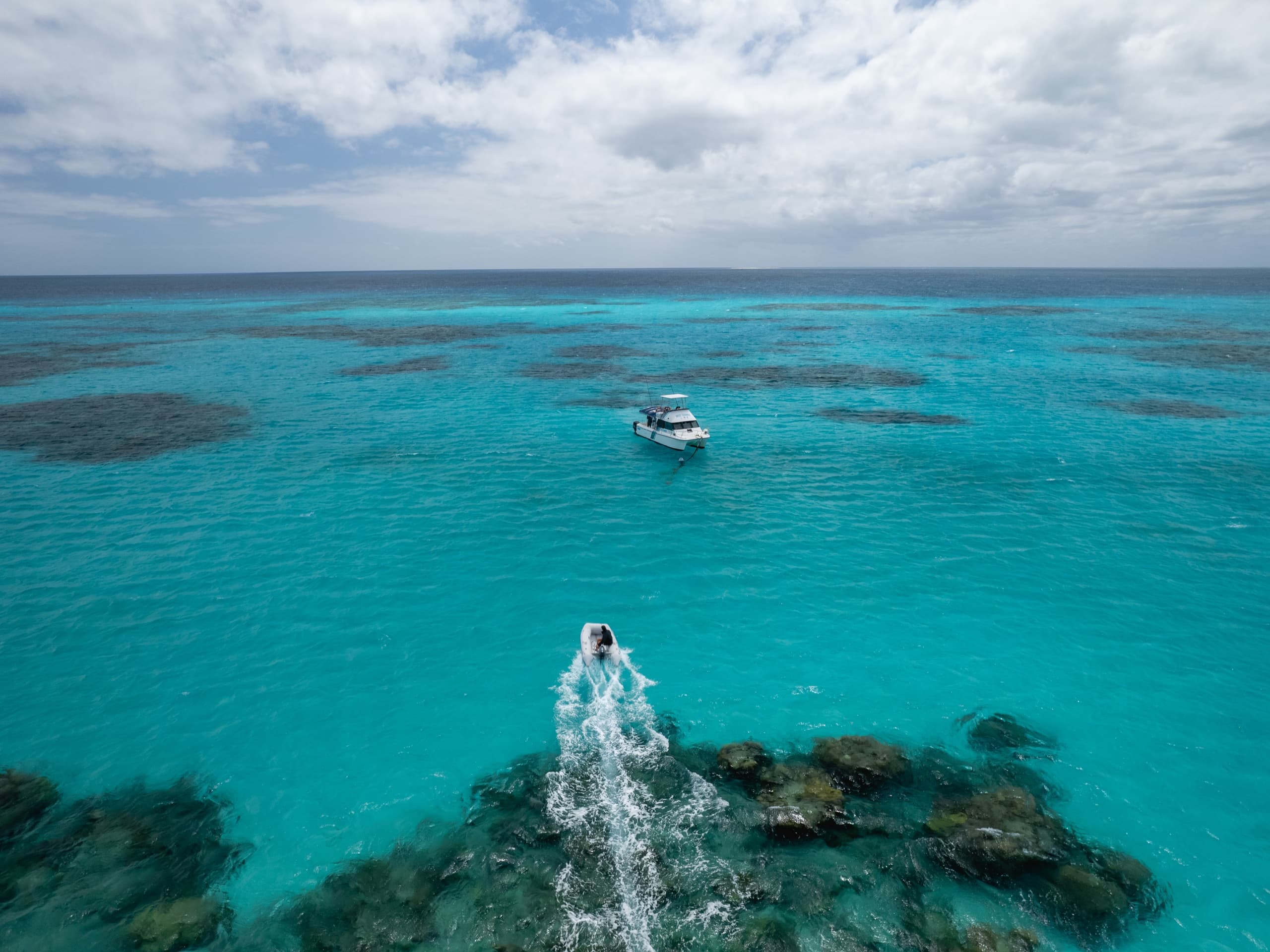 Tour boat cruising over turquoise reef waters, snorkeling adventure