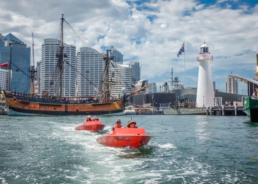 Jet boat tour with city skyline and historic tall ship