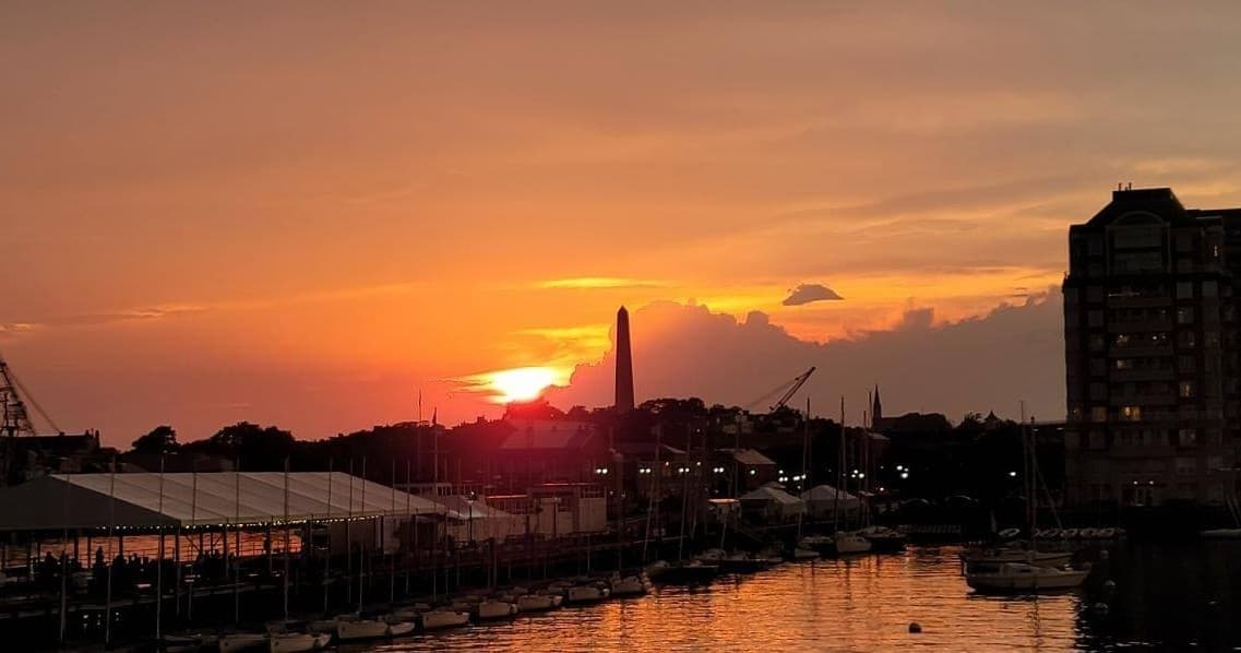 Harbor marina at sunset with boats and waterfront skyline view