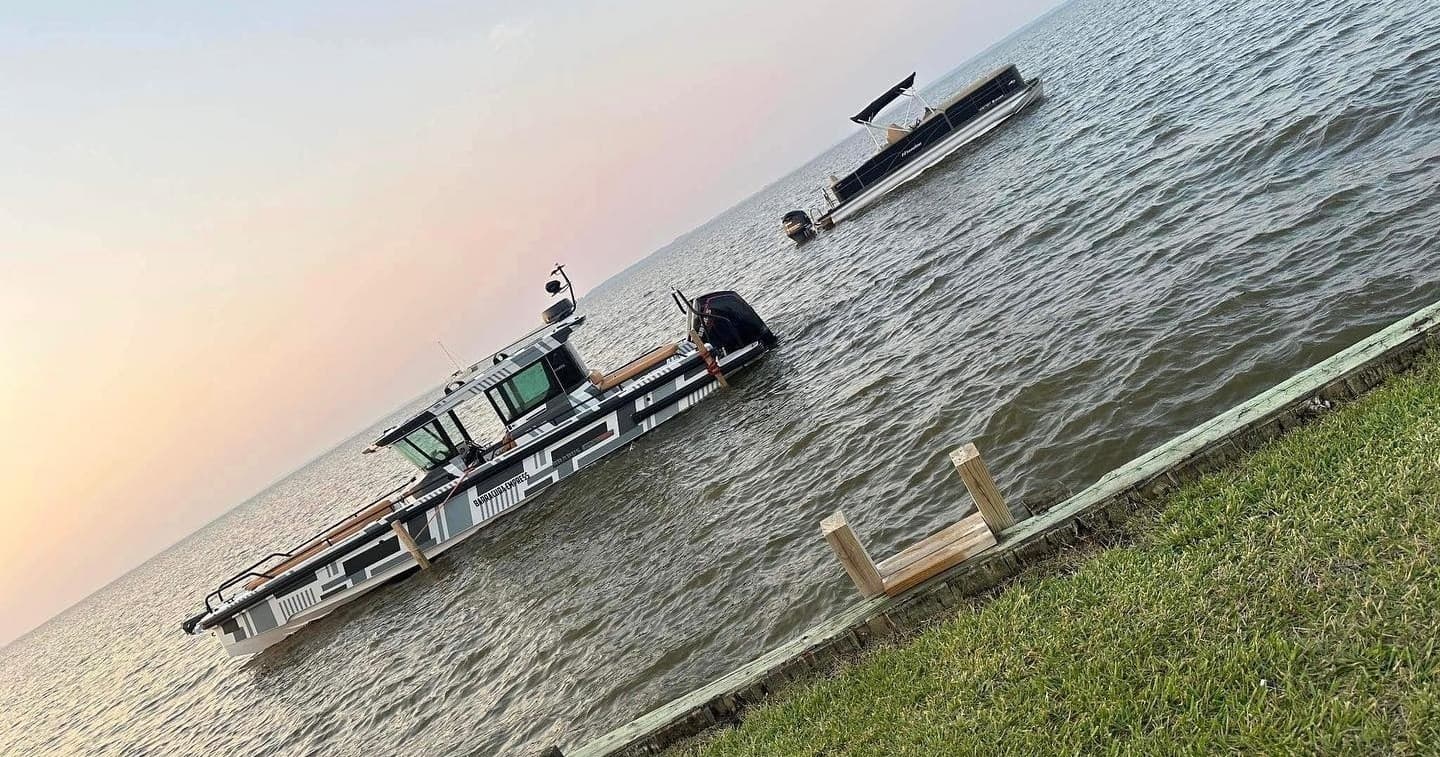 Small vessels moored near shoreline at sunset on calm water