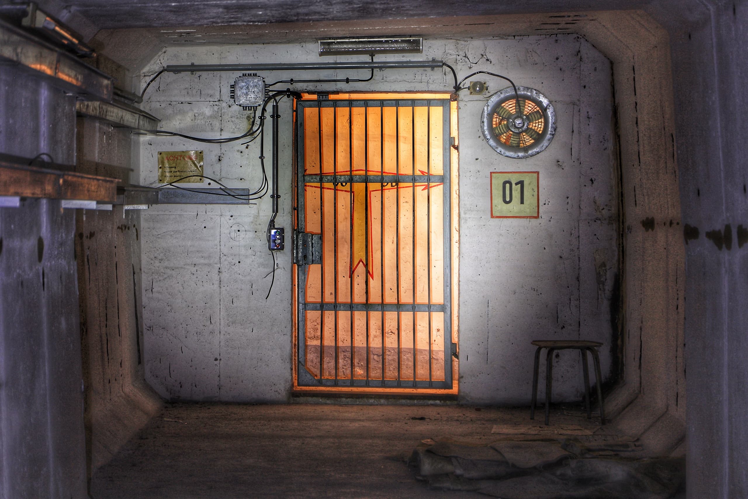 Steel-barred bunker door in concrete corridor for history tours