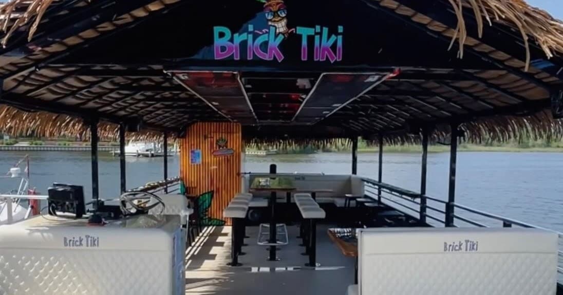 Empty tiki boat bar deck with thatched roof on lake