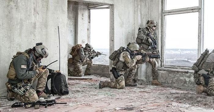 Tactical team resting in ruined urban building during daylight skirmish