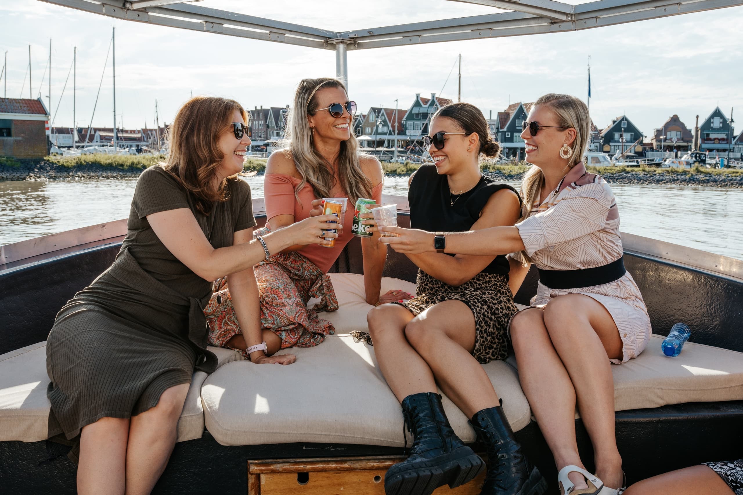 Women toasting on a marina boat, leisure cruise by harbor