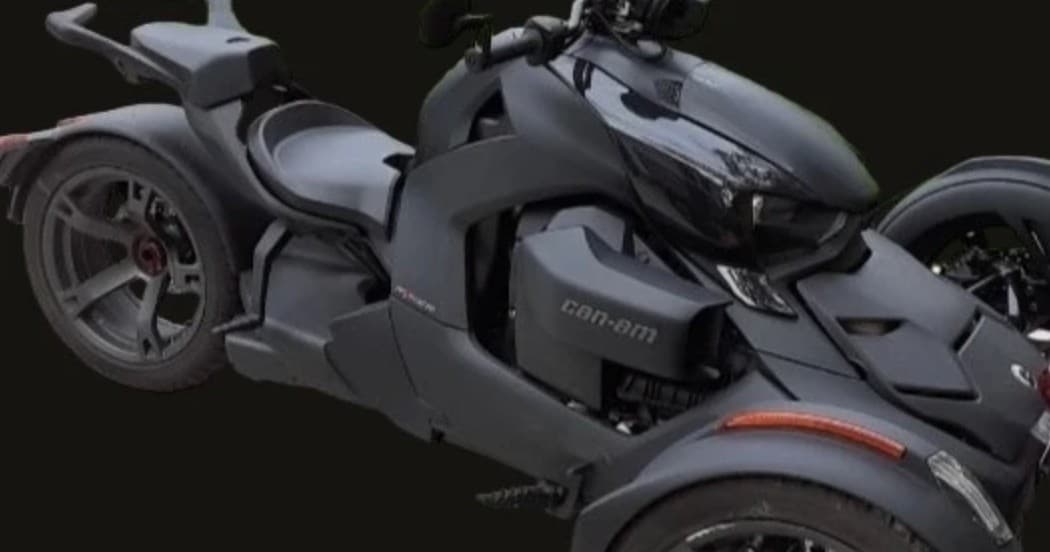 Side close-up of three-wheel touring bike on dark studio background