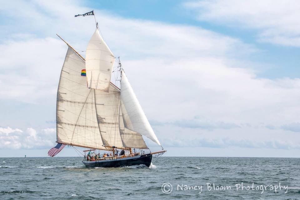 Sailing yacht with full sails cruising on calm open ocean