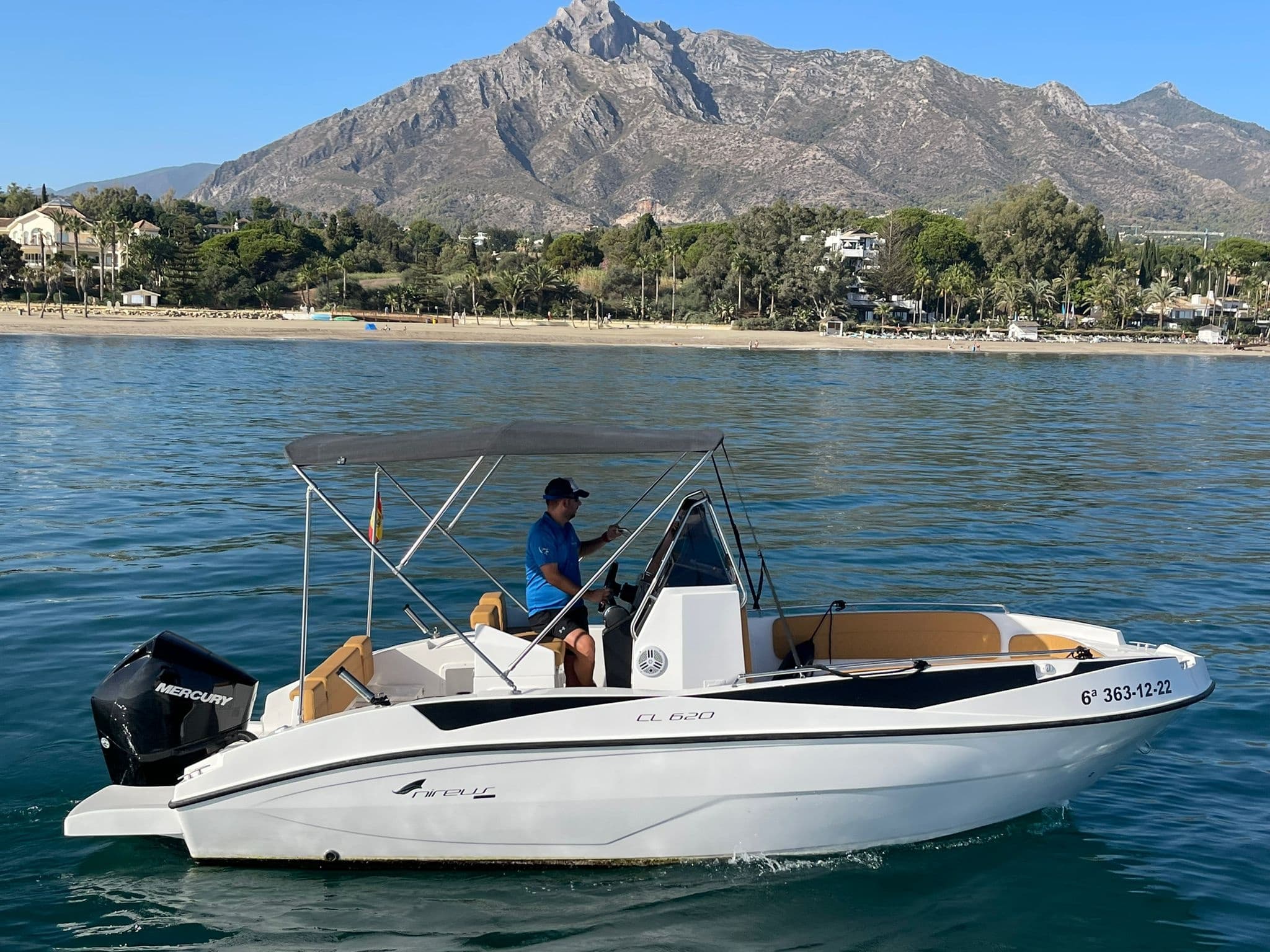 Motorboat cruising near mountainous coastline on calm sea