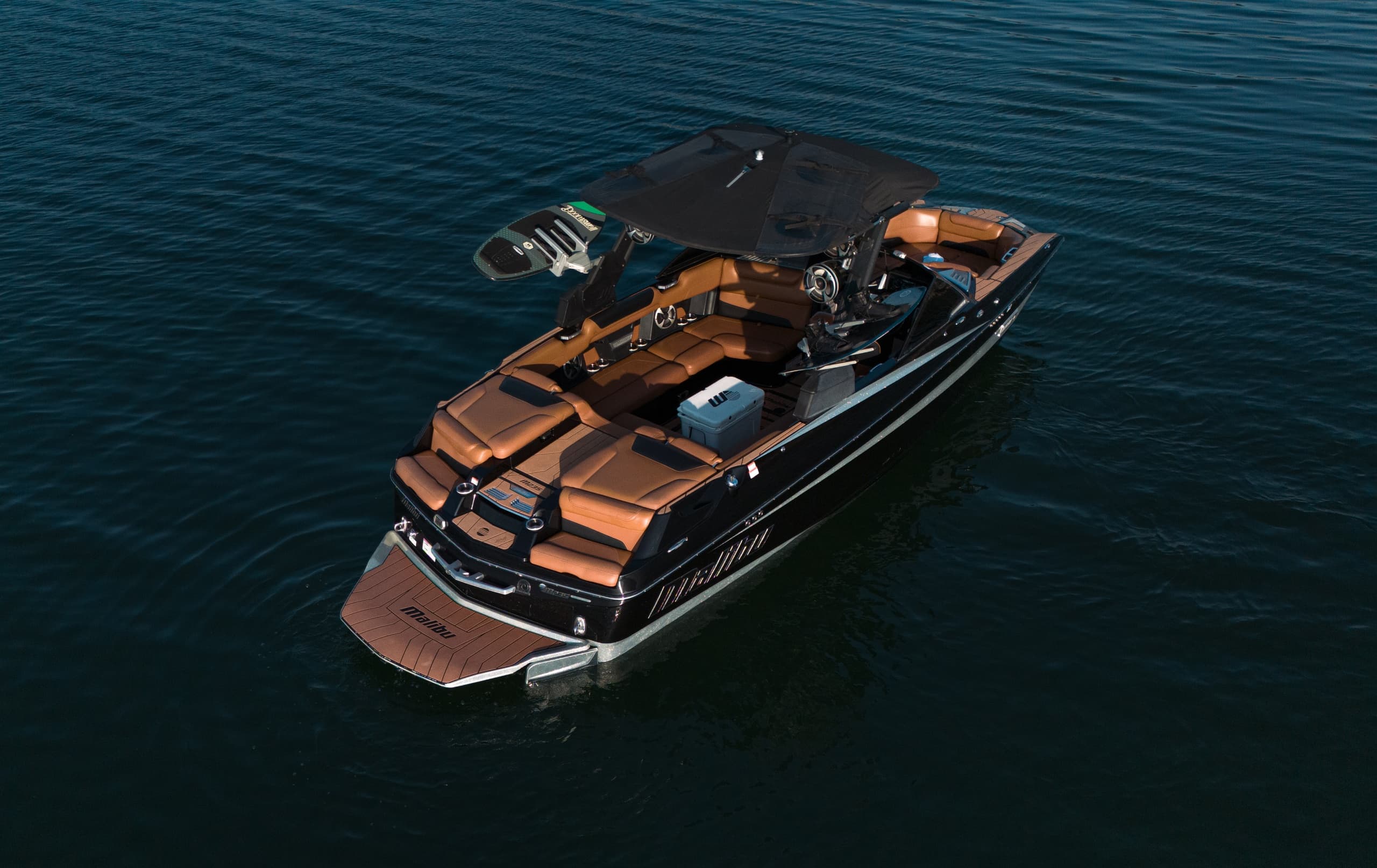 Luxury wakeboard boat cruising open lake waters at sunset