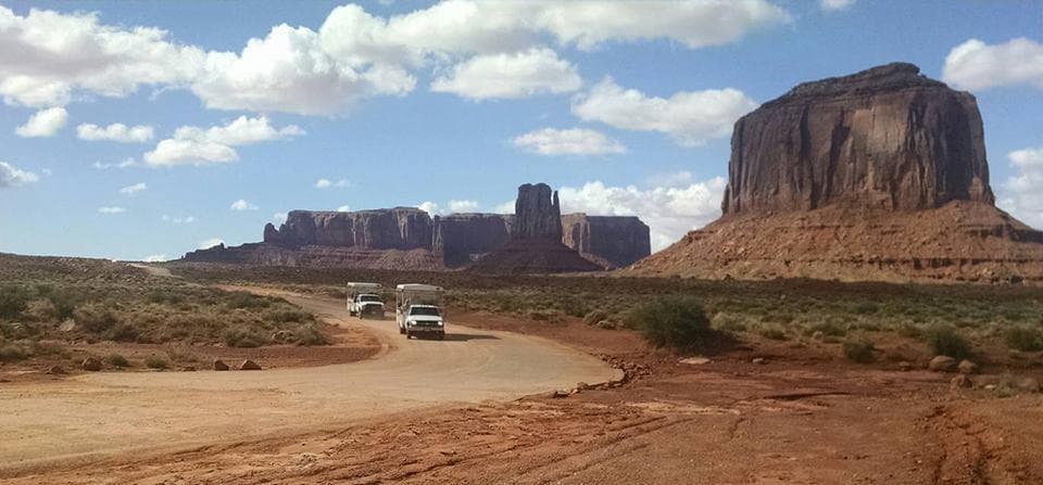 Wide Monument Valley desert panorama with scenic butte and road