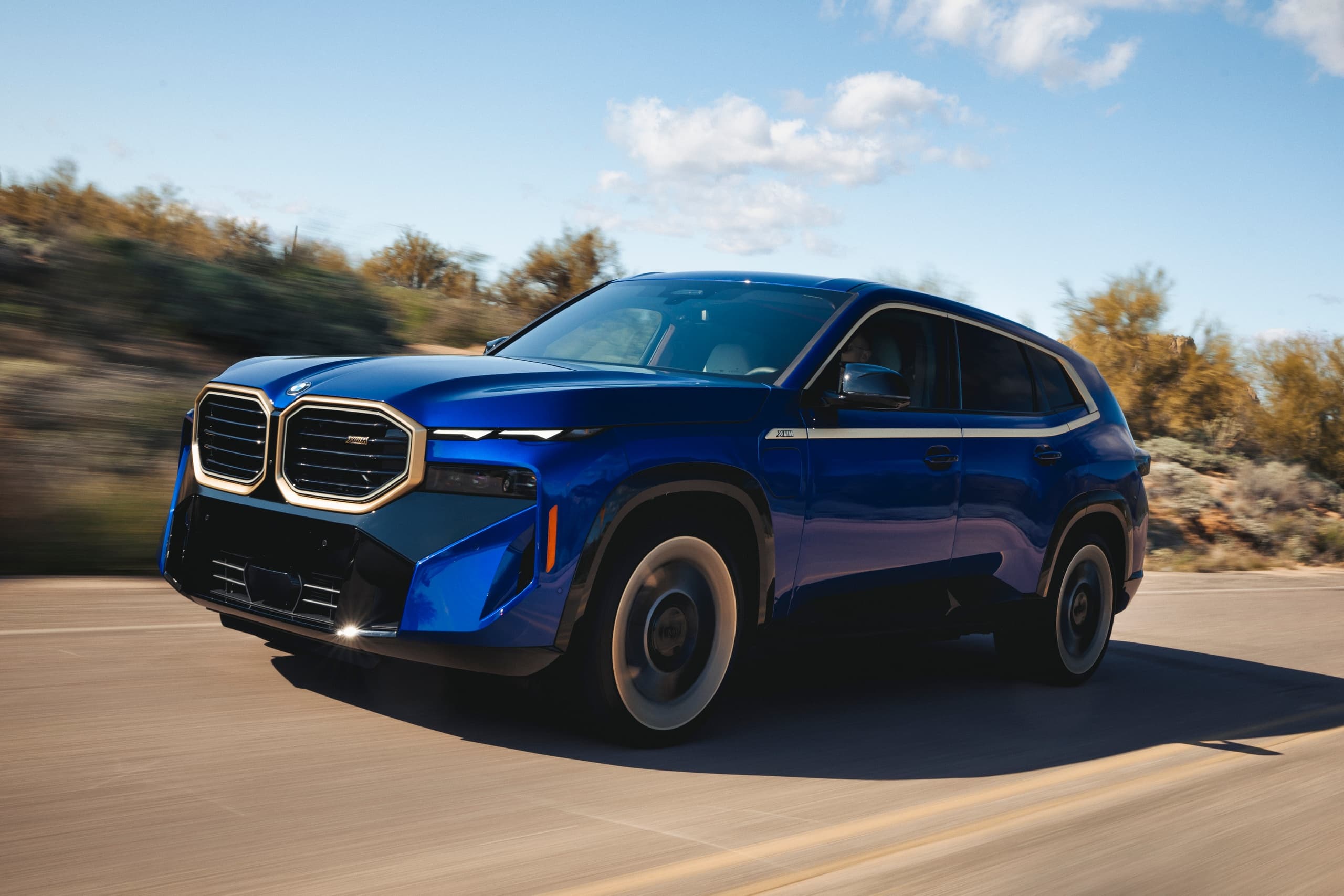 Blue BMW SUV driving on desert road during scenic highway test