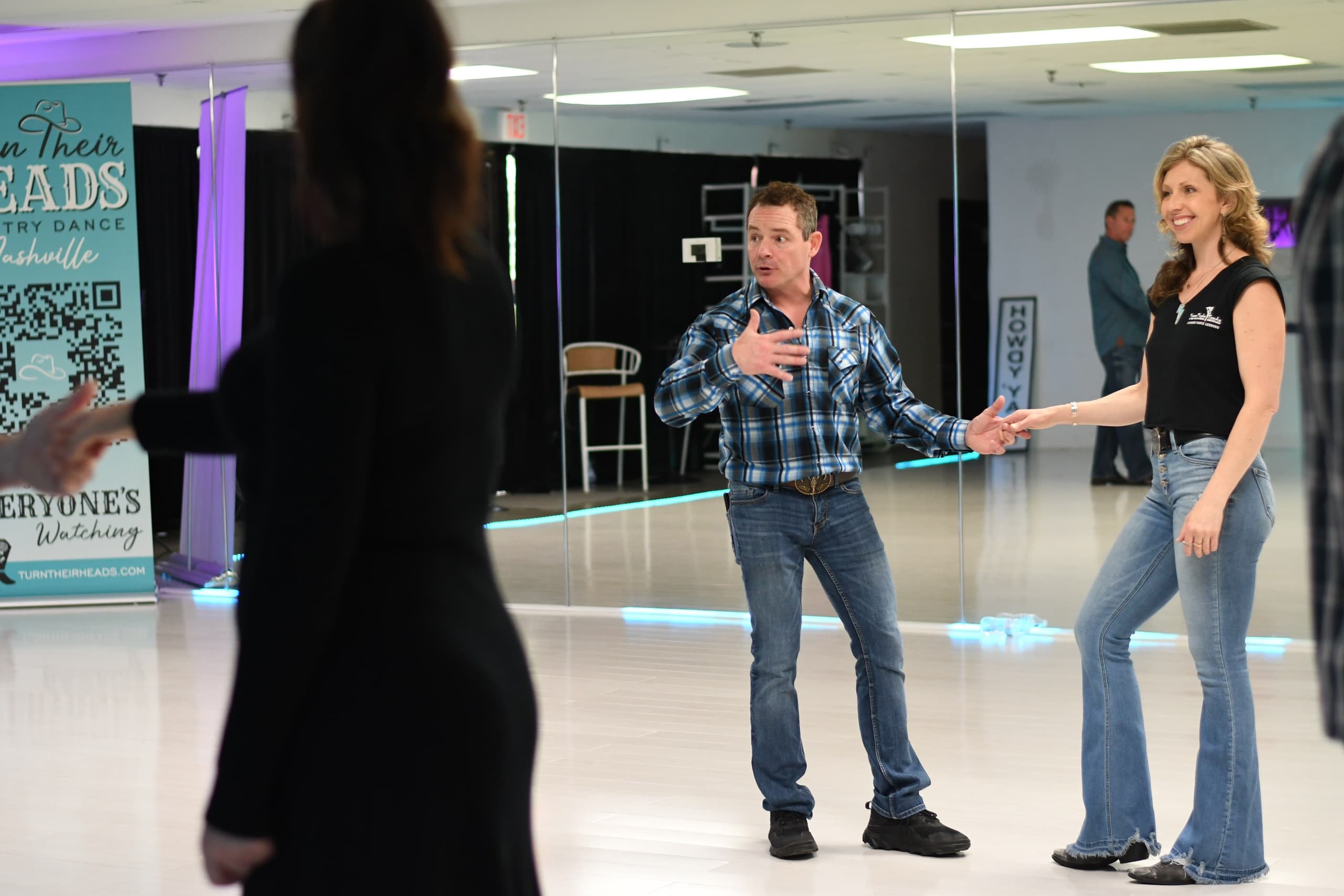 Instructors coaching couple in country dance studio lesson