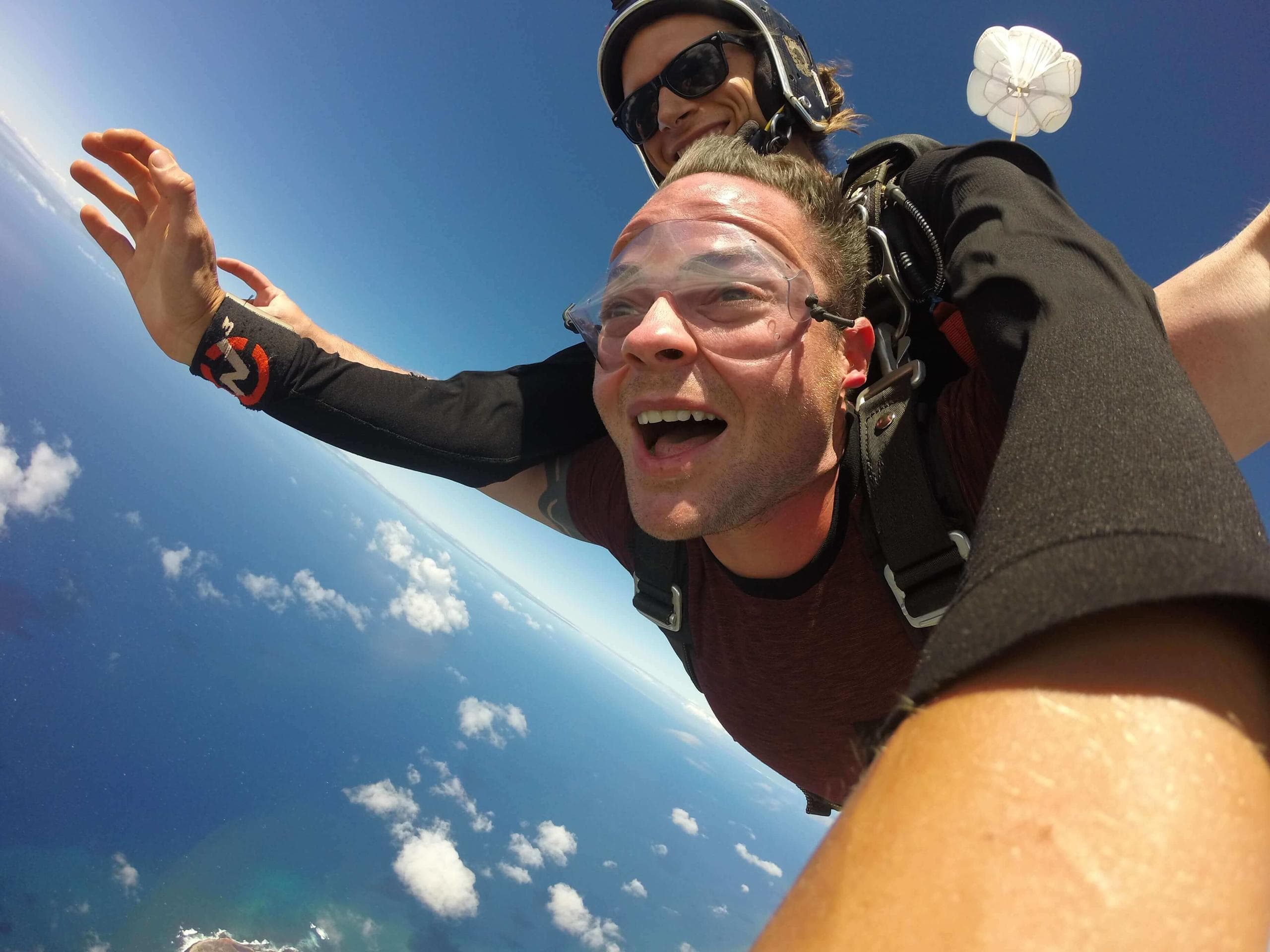 Tandem skydivers over Kauai coastline and Pacific Ocean