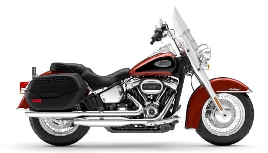 Red cruiser motorcycle on white backdrop, classic road touring vibe