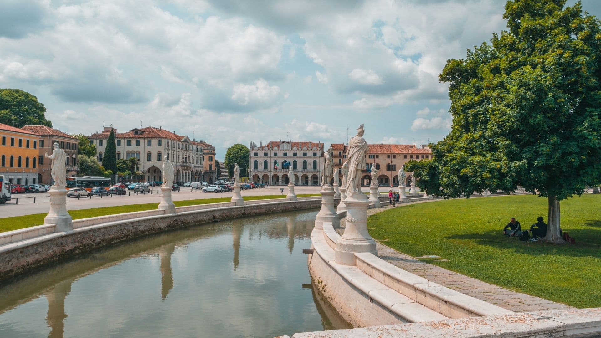 Ornamental park canal and statues, scenic lakeside promenade