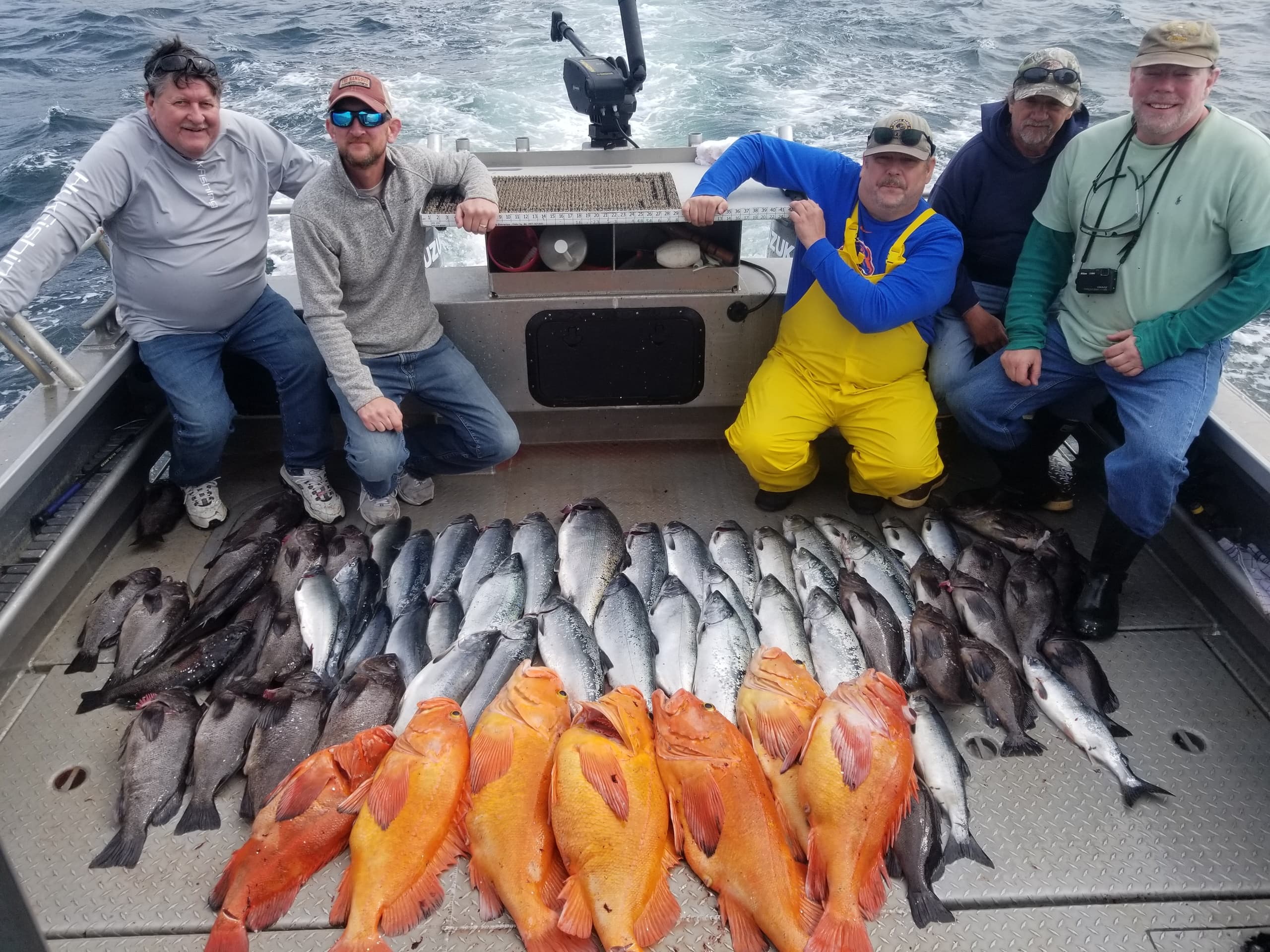Successful charter crew with vibrant rockfish and mixed catch on deck