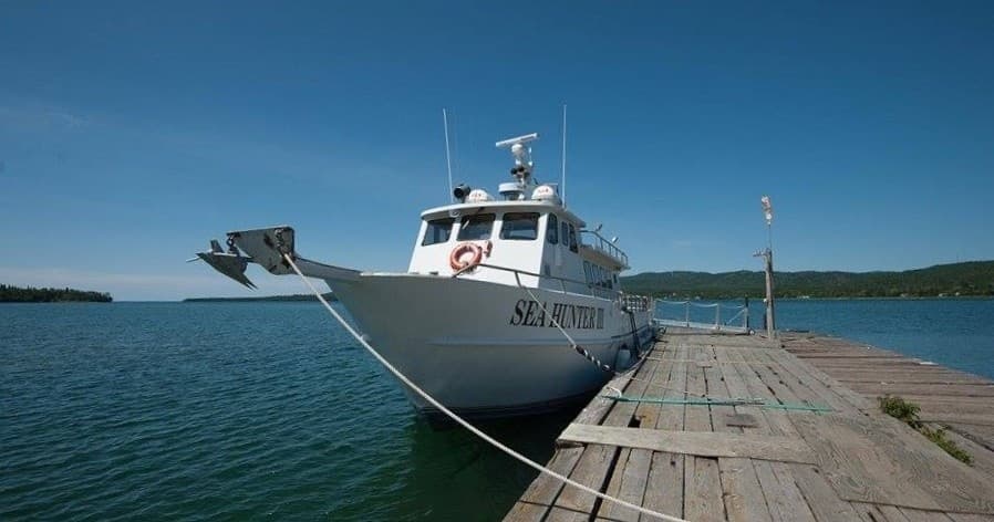 Tour vessel approaching rocky Isle Royale shore for visitor pickup