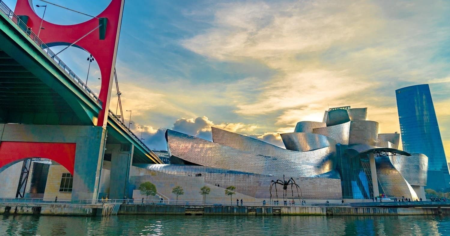Guggenheim Bilbao museum and red bridge at waterfront sunset