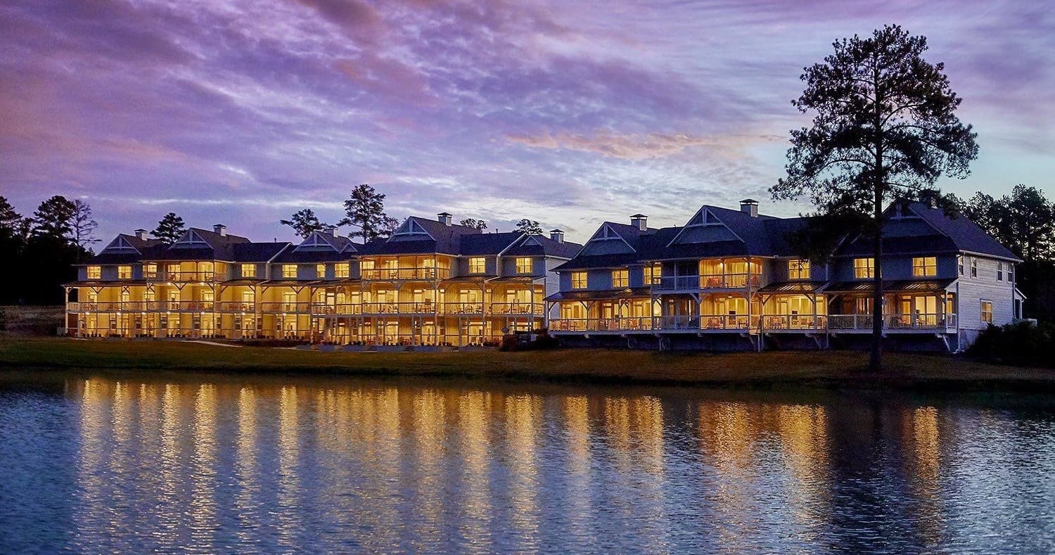 Lakeside resort lodge at sunset with calm water reflections