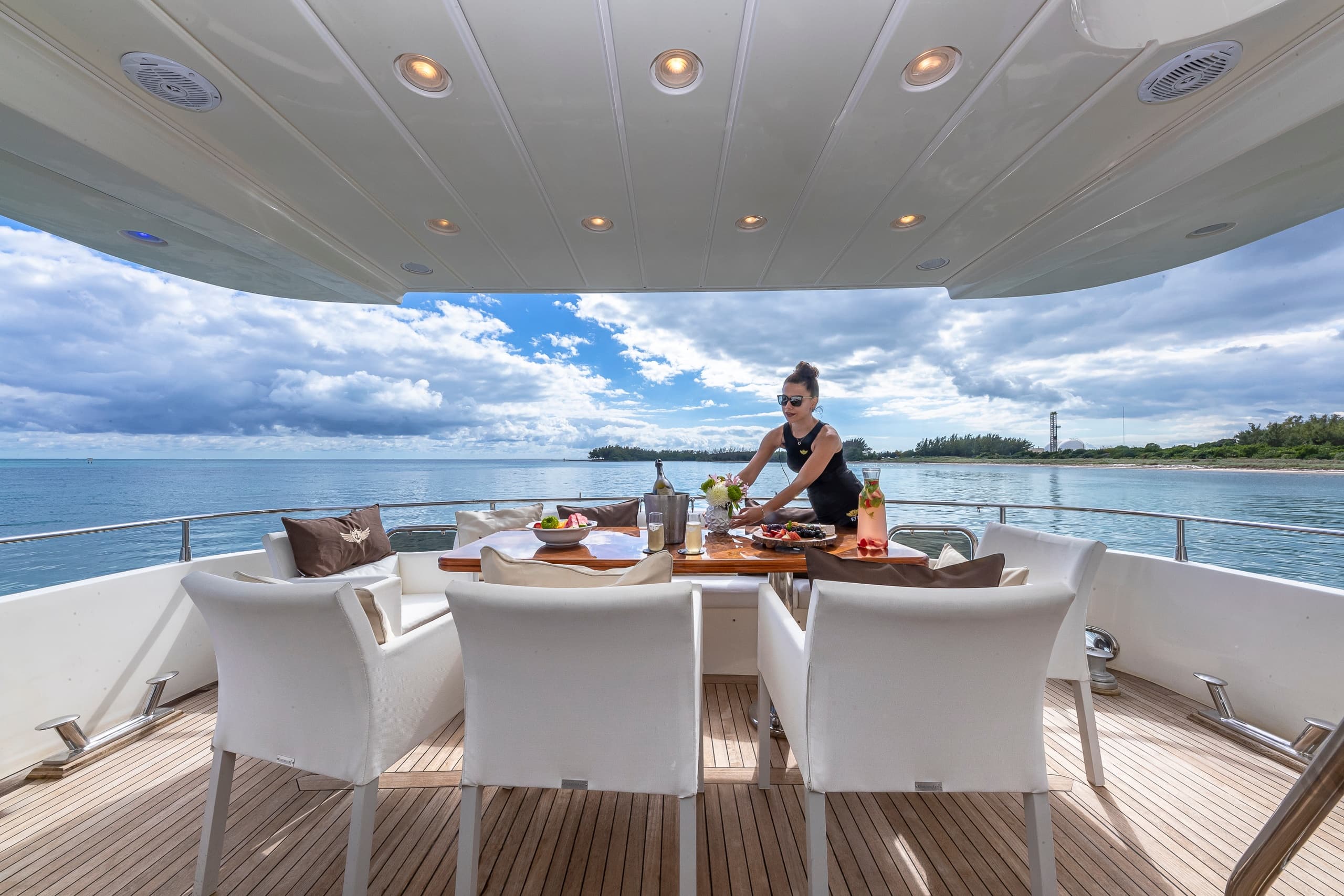Luxury yacht aft dining with ocean horizon and cloud sky