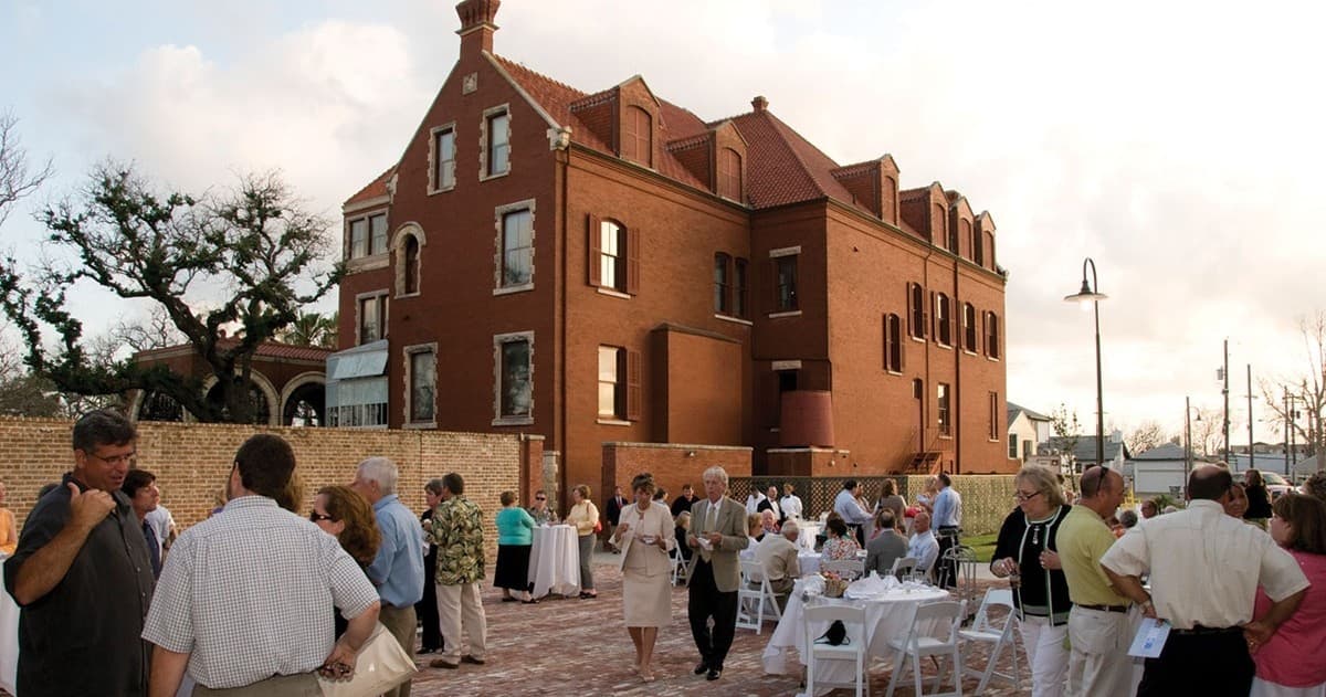 Outdoor courtyard gathering at historic mansion during sunset event