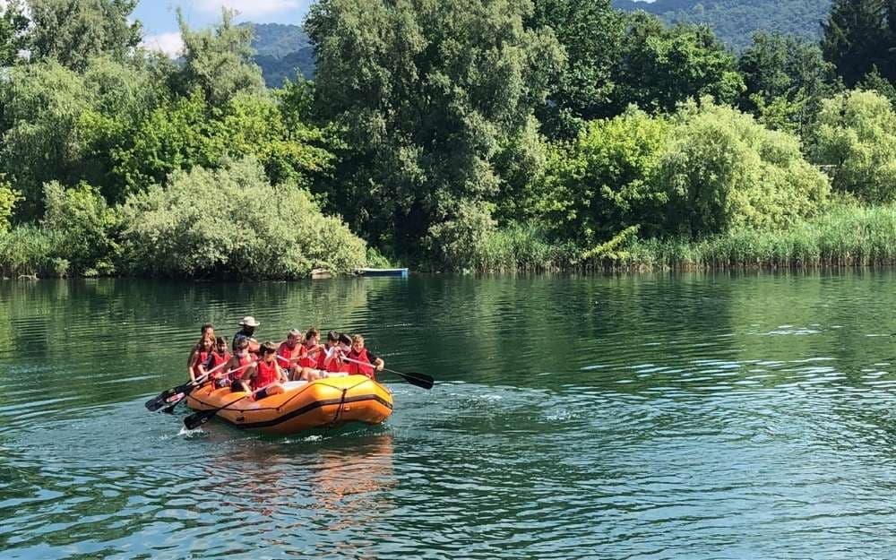 Guided rafting group on calm river surrounded by lush forest
