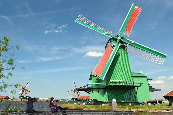Green Dutch windmill against blue sky at Zaanse Schans