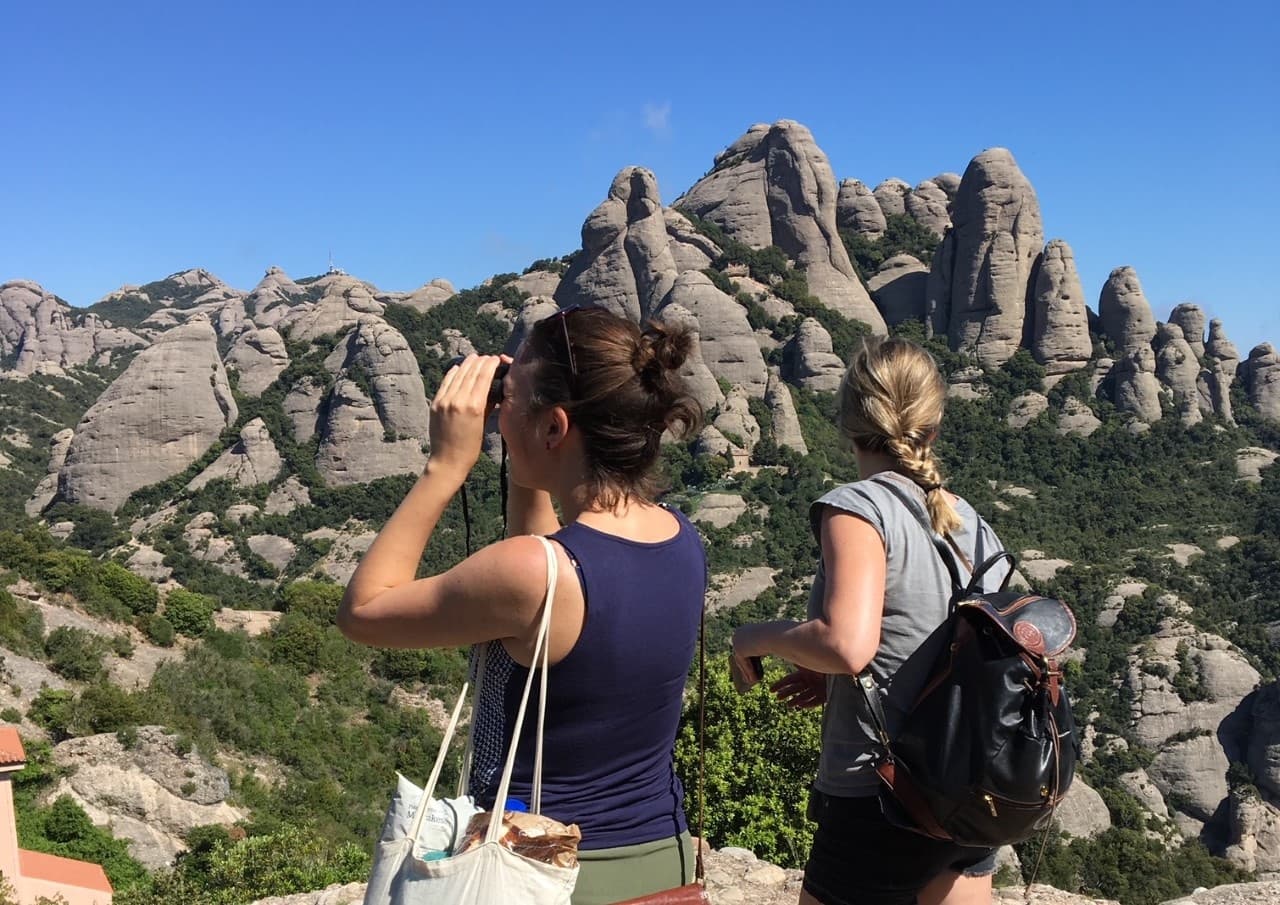 Hikers photographing Montserrat rock pinnacles from scenic viewpoint