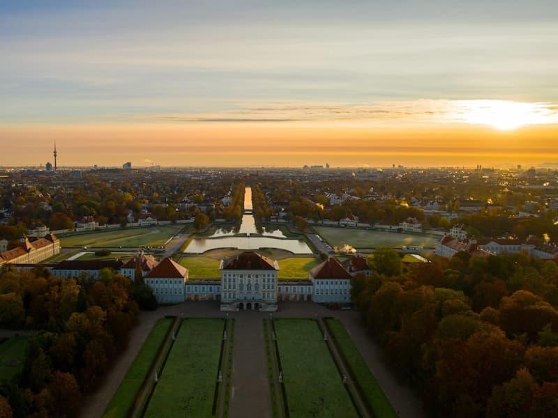 Aerial sunset over Munich palace and gardens, panoramic city view