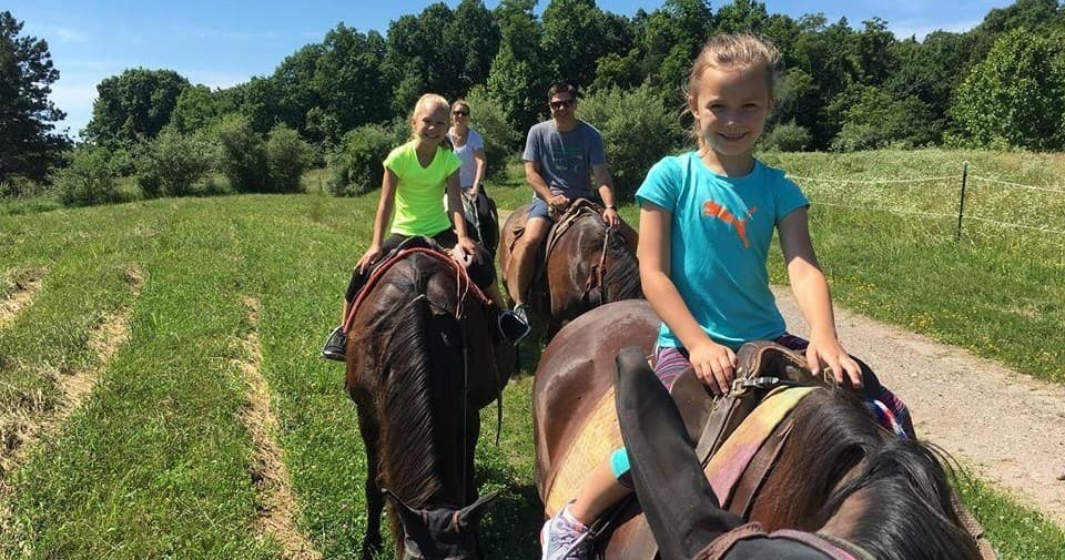Family trail horseback riding on scenic country road