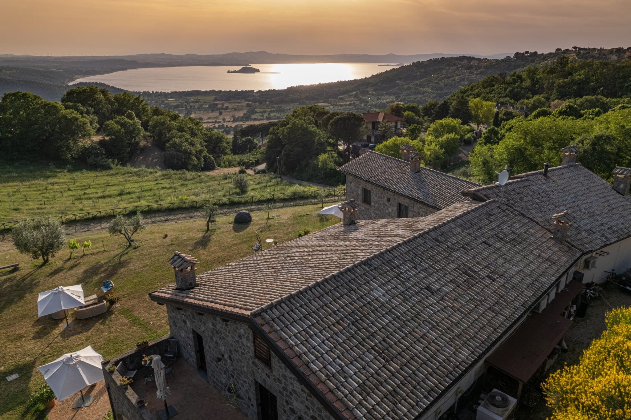 Sunset farmhouse and rolling hills overlooking Italian lake
