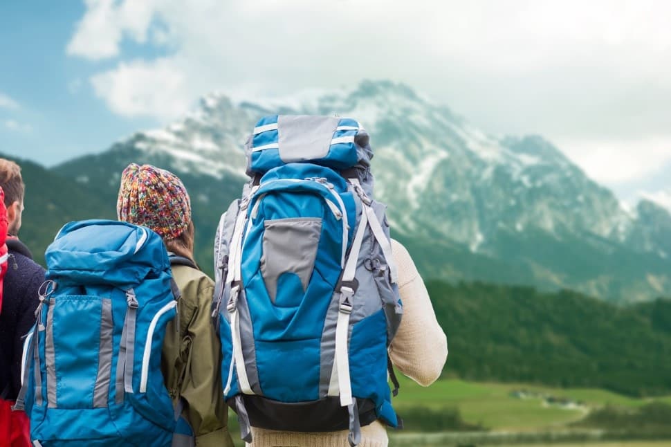 Backpack view on alpine trail overlooking distant snowy peaks